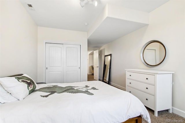 carpeted bedroom featuring visible vents, baseboards, and a closet