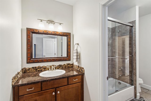 bathroom with tile patterned flooring, toilet, vanity, and bath / shower combo with glass door