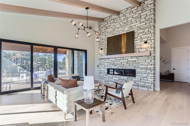 living room featuring wood-type flooring, a stone fireplace, beam ceiling, and a high ceiling