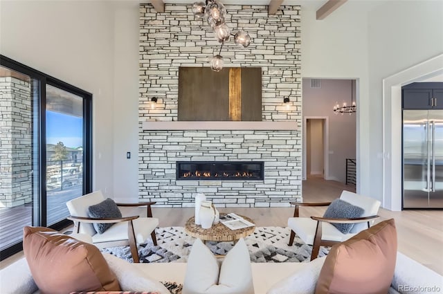 living room with a high ceiling, hardwood / wood-style floors, a fireplace, and beam ceiling