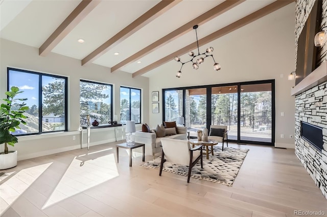 living room featuring a healthy amount of sunlight, a fireplace, and high vaulted ceiling