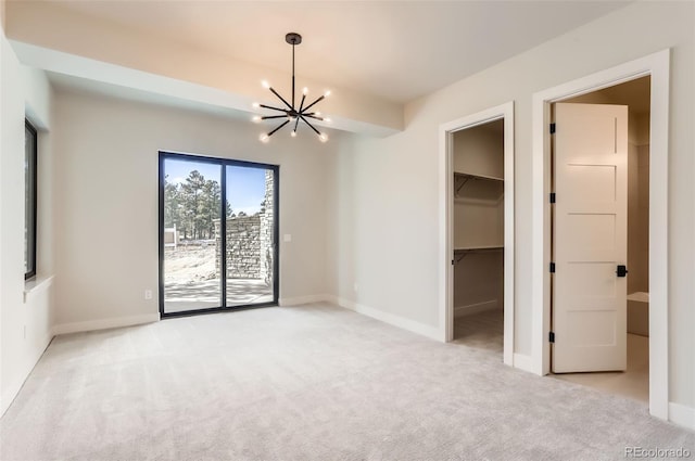 empty room with an inviting chandelier and light colored carpet