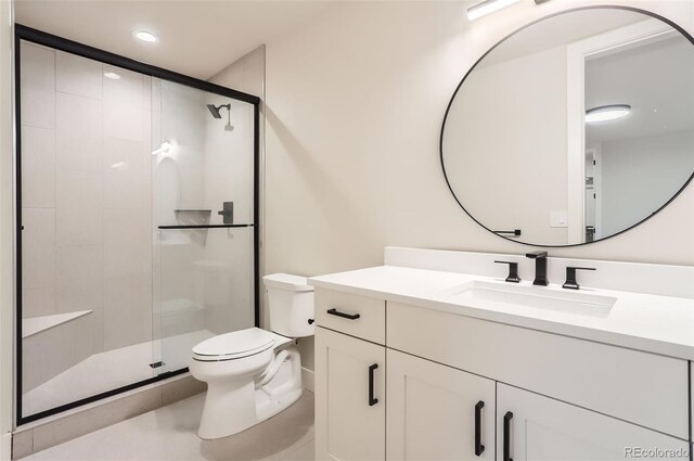 bathroom featuring vanity, toilet, and a shower with door