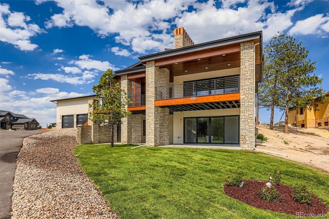 5820 Powell Rd, Parker, CO 80134 - back of property featuring a balcony, stone siding, a yard, and a chimney