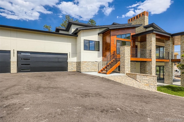 5820 Powell Rd, Parker, CO 80134 - contemporary house featuring stone siding, stucco siding, a garage, asphalt driveway, and stairway