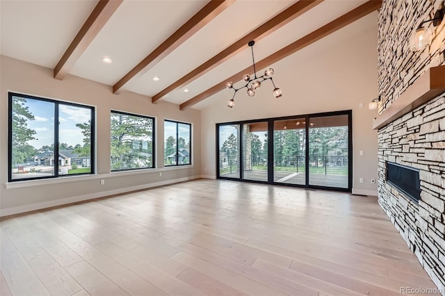5820 Powell Rd, Parker, CO 80134 - unfurnished living room with beamed ceiling, a stone fireplace, high vaulted ceiling, a chandelier, and light wood finished floors