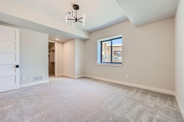 5820 Powell Rd, Parker, CO 80134 - unfurnished bedroom with a chandelier, light colored carpet, a walk in closet, and a closet