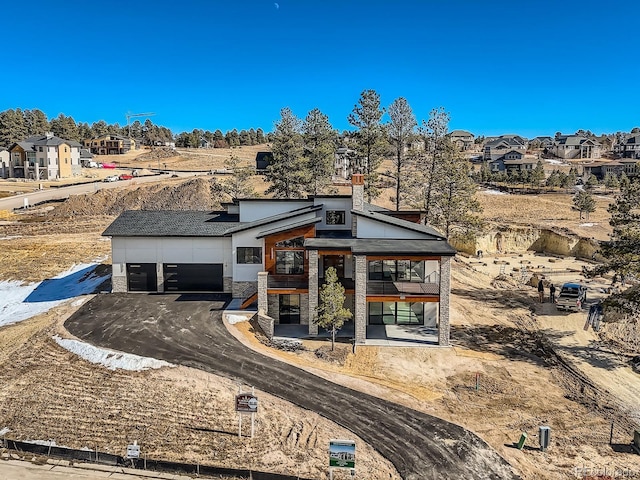 5820 Powell Rd, Parker, CO 80134 - view of front of house with stone siding, a garage, asphalt driveway, and a residential view