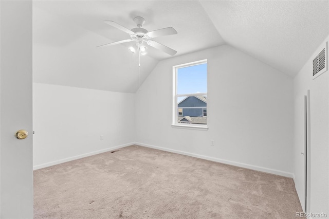 bonus room with light carpet, a textured ceiling, ceiling fan, and lofted ceiling