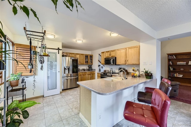 17076 Foxton Dr, Parker, CO 80134 - kitchen with appliances with stainless steel finishes, a peninsula, a sink, glass insert cabinets, and light countertops