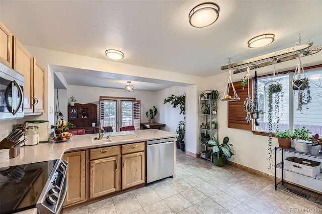 17076 Foxton Dr, Parker, CO 80134 - kitchen featuring stainless steel appliances, a peninsula, a sink, light countertops, and baseboards