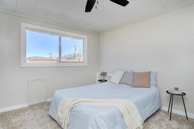 carpeted bedroom featuring baseboards and a ceiling fan