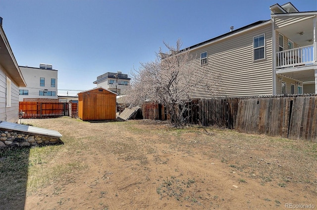 view of yard with an outbuilding, a fenced backyard, and a storage unit