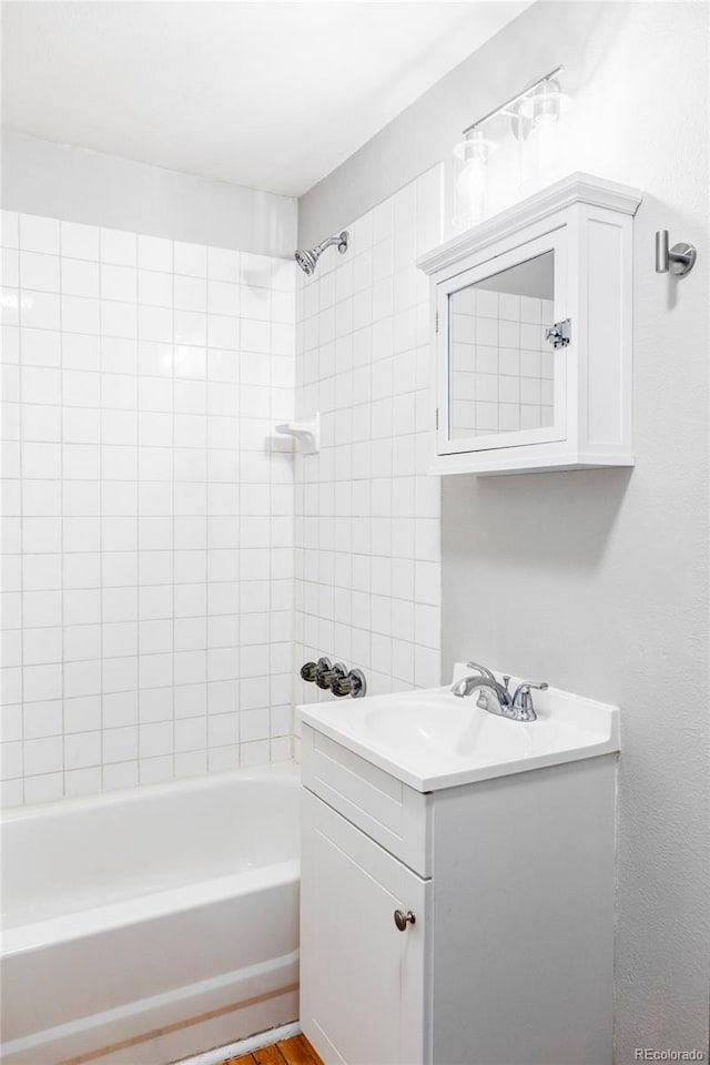 bathroom featuring tiled shower / bath and vanity