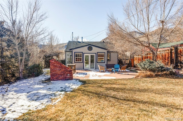 rear view of property featuring a patio and a lawn