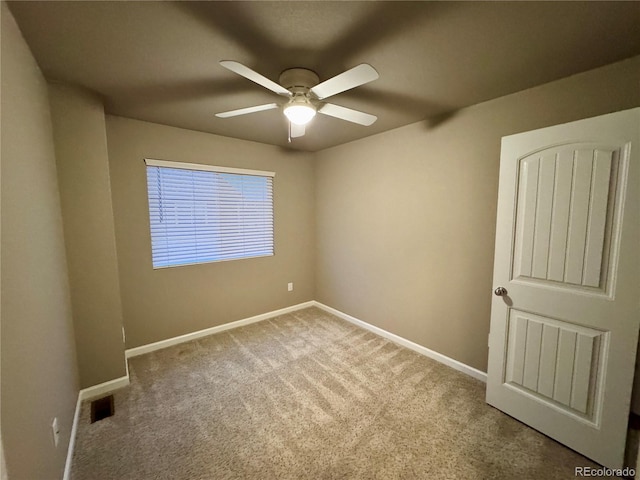 carpeted spare room with ceiling fan