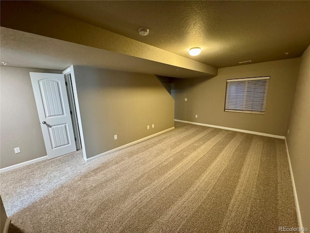 basement featuring carpet and a textured ceiling