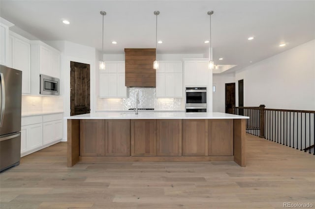 kitchen with white cabinetry, decorative backsplash, a spacious island, and appliances with stainless steel finishes