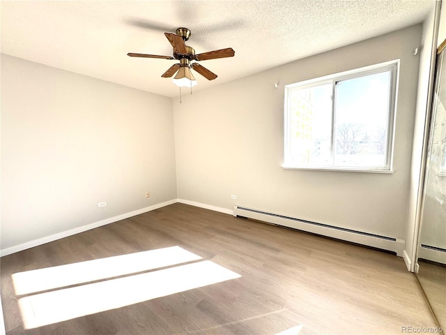 755 S Alton Way Unit 12C, Denver, CO 80247 - spare room featuring wood finished floors, ceiling fan, a baseboard radiator, and baseboards