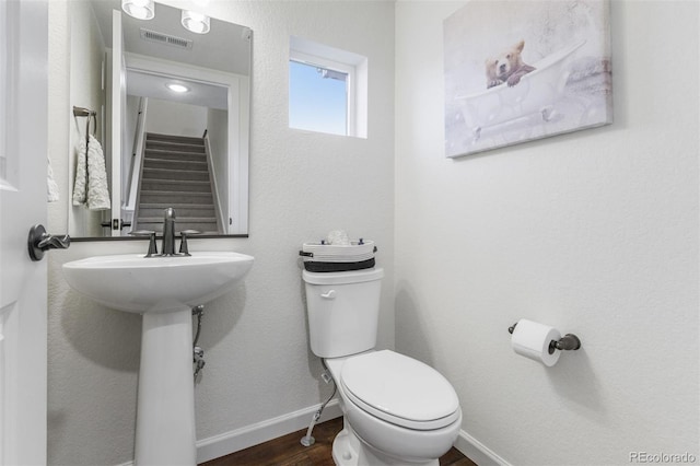 bathroom with toilet and hardwood / wood-style flooring