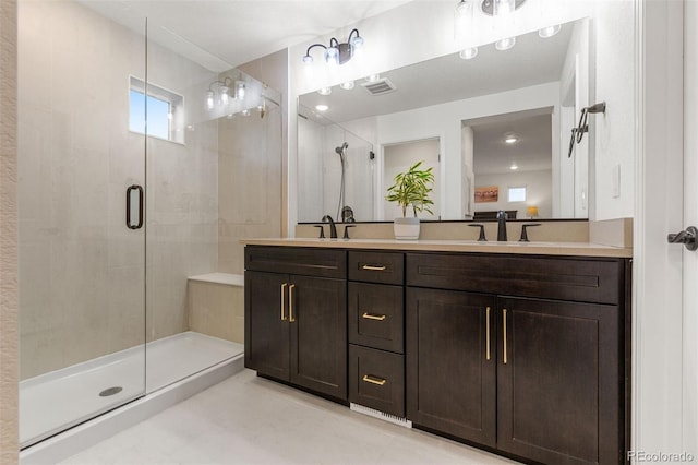 bathroom featuring a shower with door and vanity