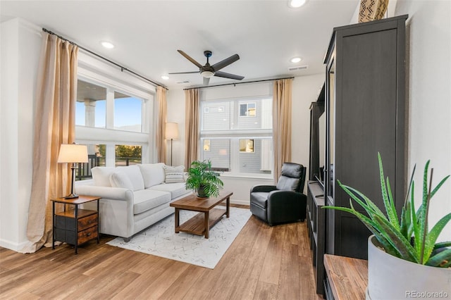 living room with ceiling fan and light hardwood / wood-style flooring