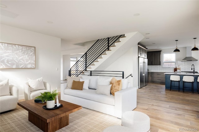 living room with light wood-type flooring and sink