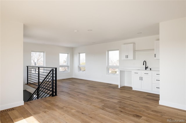 unfurnished room featuring sink and light hardwood / wood-style flooring