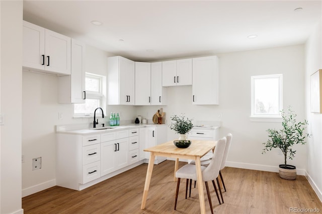 kitchen with sink, white cabinets, and light hardwood / wood-style floors