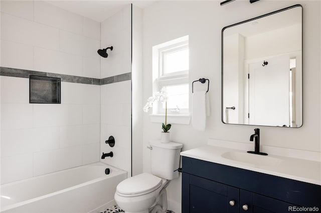 full bathroom featuring vanity, tiled shower / bath, and toilet