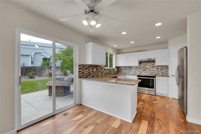 11091 Clayton St, Northglenn, CO 80233 - kitchen featuring stainless steel appliances, tasteful backsplash, ceiling fan, a peninsula, and light wood-style floors