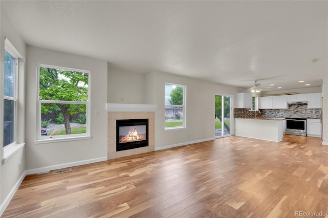 11091 Clayton St, Northglenn, CO 80233 - unfurnished living room with healthy amount of natural light, a fireplace, light wood-style flooring, and recessed lighting