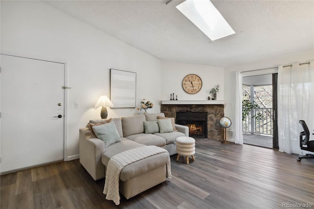 living area featuring a skylight, baseboards, a fireplace, and wood finished floors