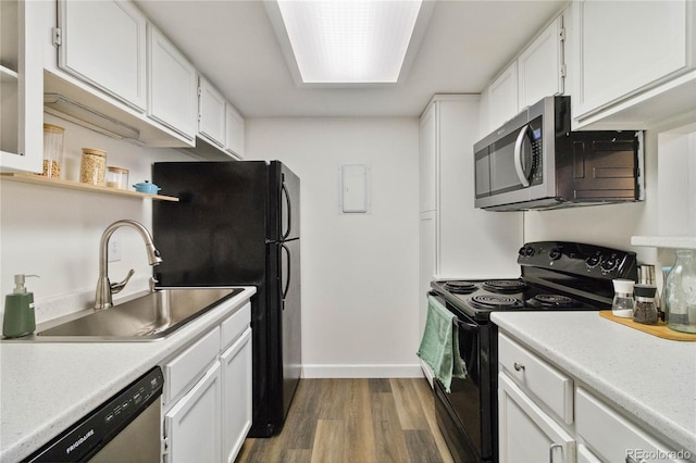 kitchen featuring open shelves, a sink, light wood-style flooring, white cabinetry, and black appliances