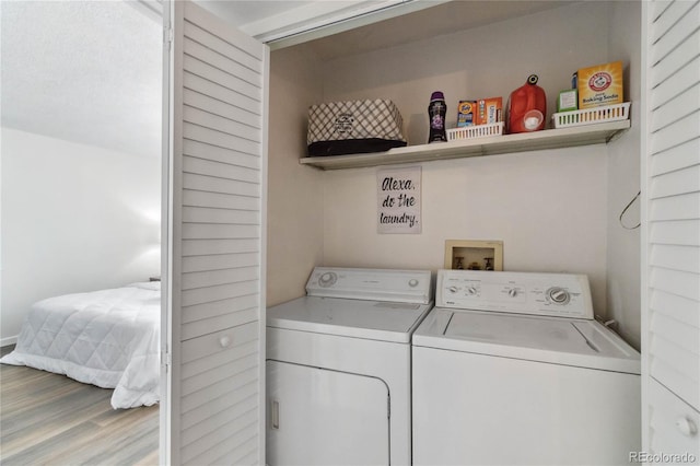 laundry room featuring laundry area, washing machine and dryer, and wood finished floors