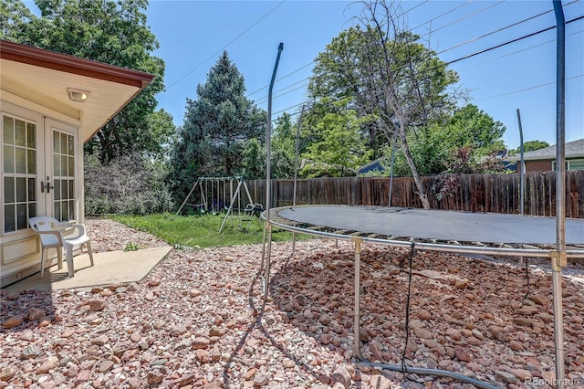 233 Nome St, Aurora, CO 80010 - fenced backyard featuring a trampoline, french doors, and a playground