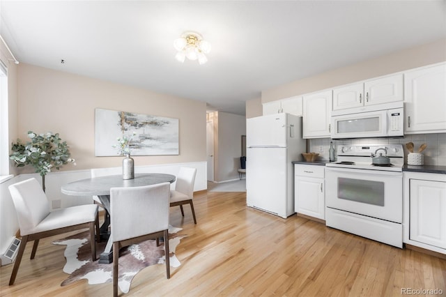 1185 Yank St, Golden, CO 80401 - kitchen featuring white appliances, light wood-style flooring, white cabinets, tasteful backsplash, and dark countertops