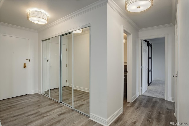 corridor with hardwood / wood-style floors and crown molding