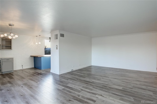 unfurnished living room with wine cooler, ornamental molding, a notable chandelier, and hardwood / wood-style flooring