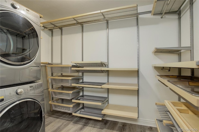 laundry area with dark hardwood / wood-style flooring and stacked washer and dryer