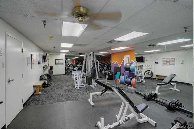 gym with a paneled ceiling and ceiling fan