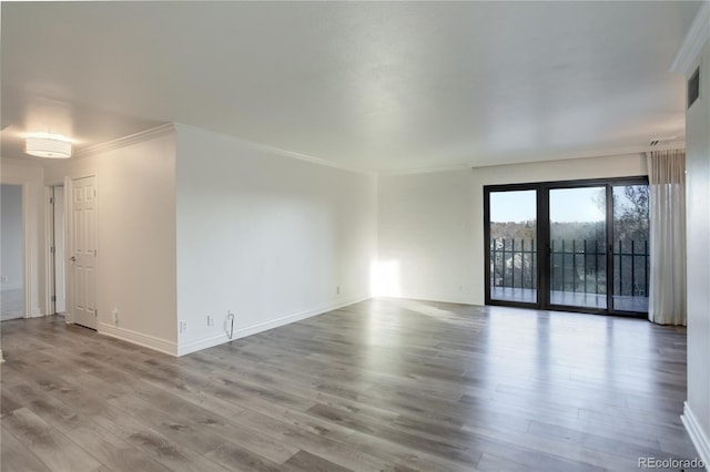 unfurnished room featuring light wood finished floors, baseboards, and ornamental molding