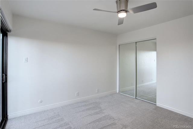 unfurnished bedroom with light carpet, a ceiling fan, baseboards, and a closet