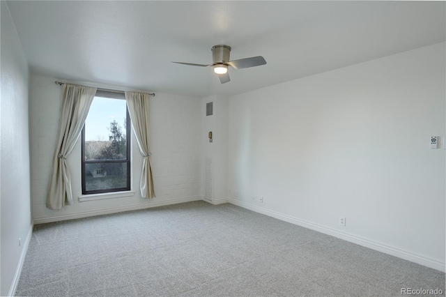 carpeted empty room with a ceiling fan, visible vents, and baseboards