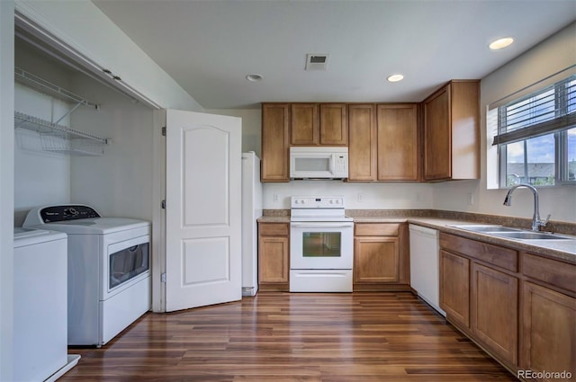 19249 E 58th Ave Unit D, Denver, CO 80249 - kitchen featuring white appliances, washer and clothes dryer, a sink, brown cabinetry, and dark wood finished floors