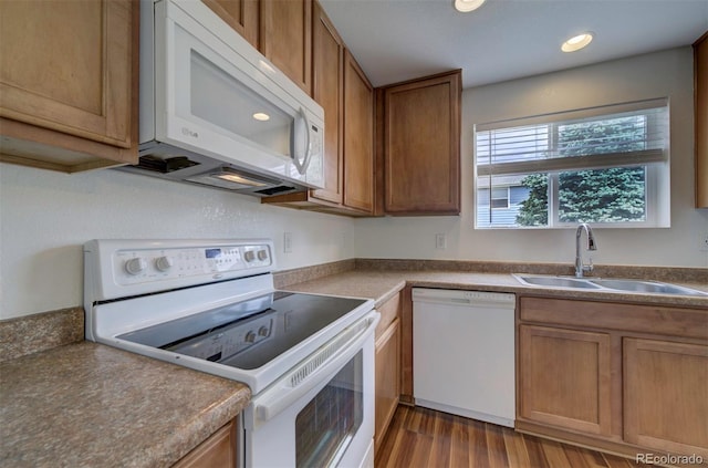 19249 E 58th Ave Unit D, Denver, CO 80249 - kitchen featuring white appliances, a sink, wood finished floors, brown cabinetry, and recessed lighting