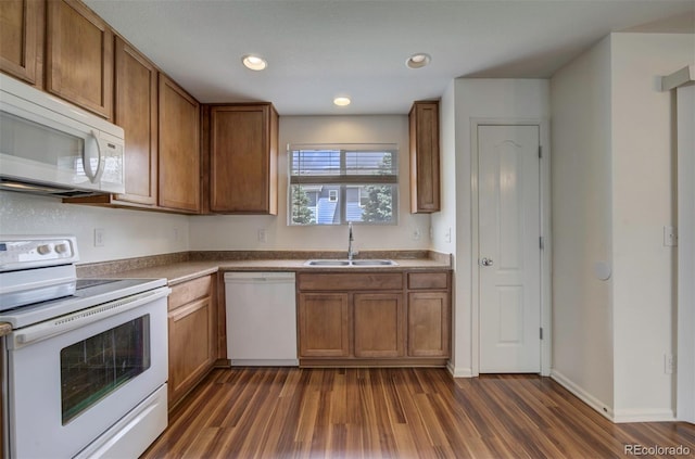 19249 E 58th Ave Unit D, Denver, CO 80249 - kitchen featuring white appliances, a sink, dark wood-style flooring, brown cabinetry, and dark countertops