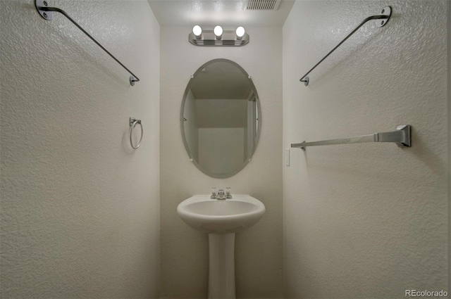 19249 E 58th Ave Unit D, Denver, CO 80249 - bathroom featuring a textured wall and a sink