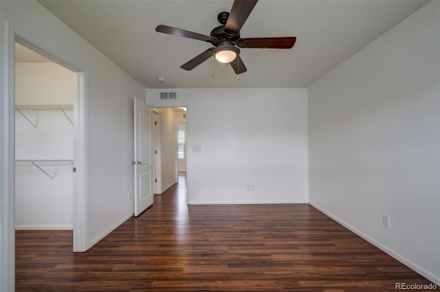 19249 E 58th Ave Unit D, Denver, CO 80249 - unfurnished bedroom with wood finished floors, a closet, baseboards, and a walk in closet