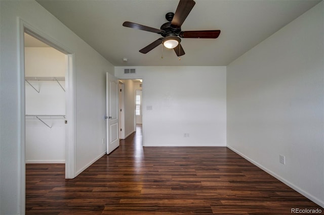 19249 E 58th Ave Unit D, Denver, CO 80249 - unfurnished bedroom featuring wood finished floors, a closet, baseboards, a ceiling fan, and a walk in closet